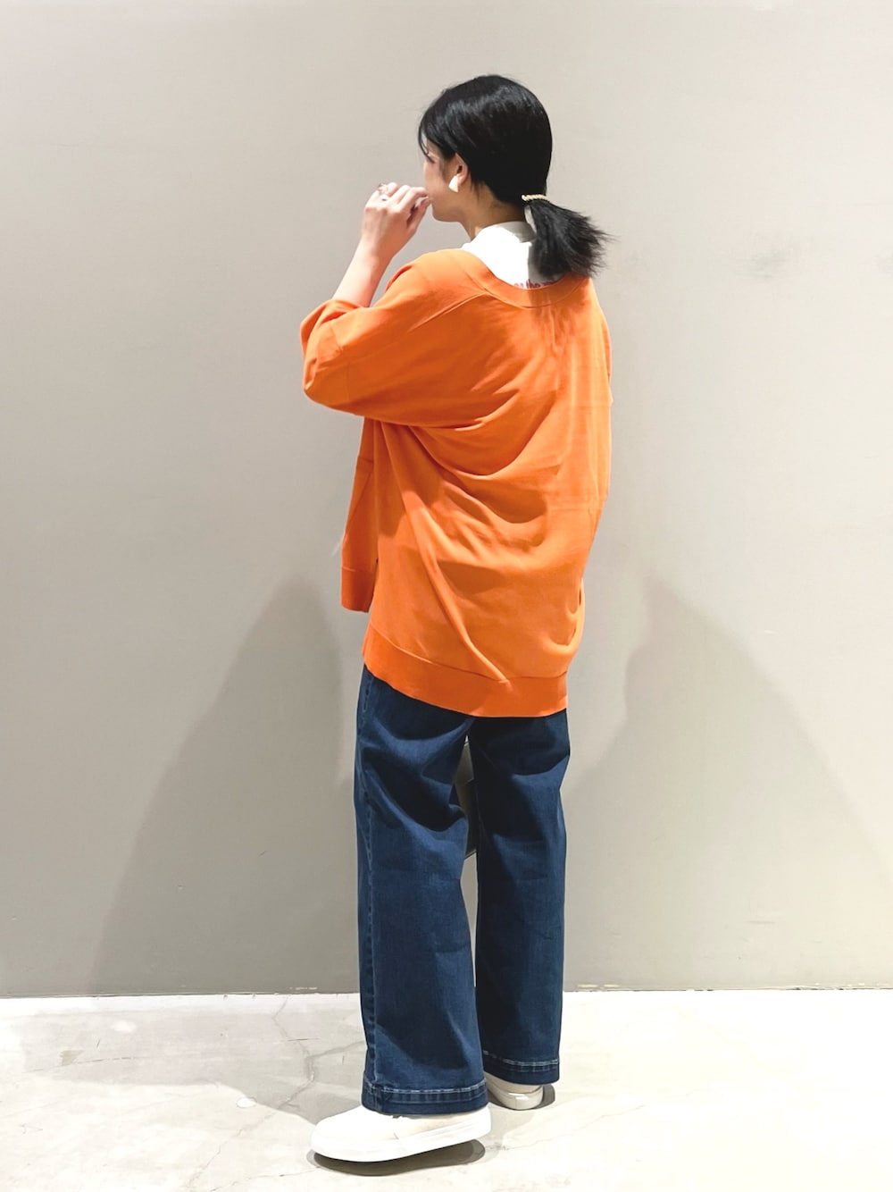 ブルー系のデニムパンツ、ホワイト系のシューズ、ホワイト系のショルダーバッグを着用したレディースの夏コーディネートの2枚目の写真