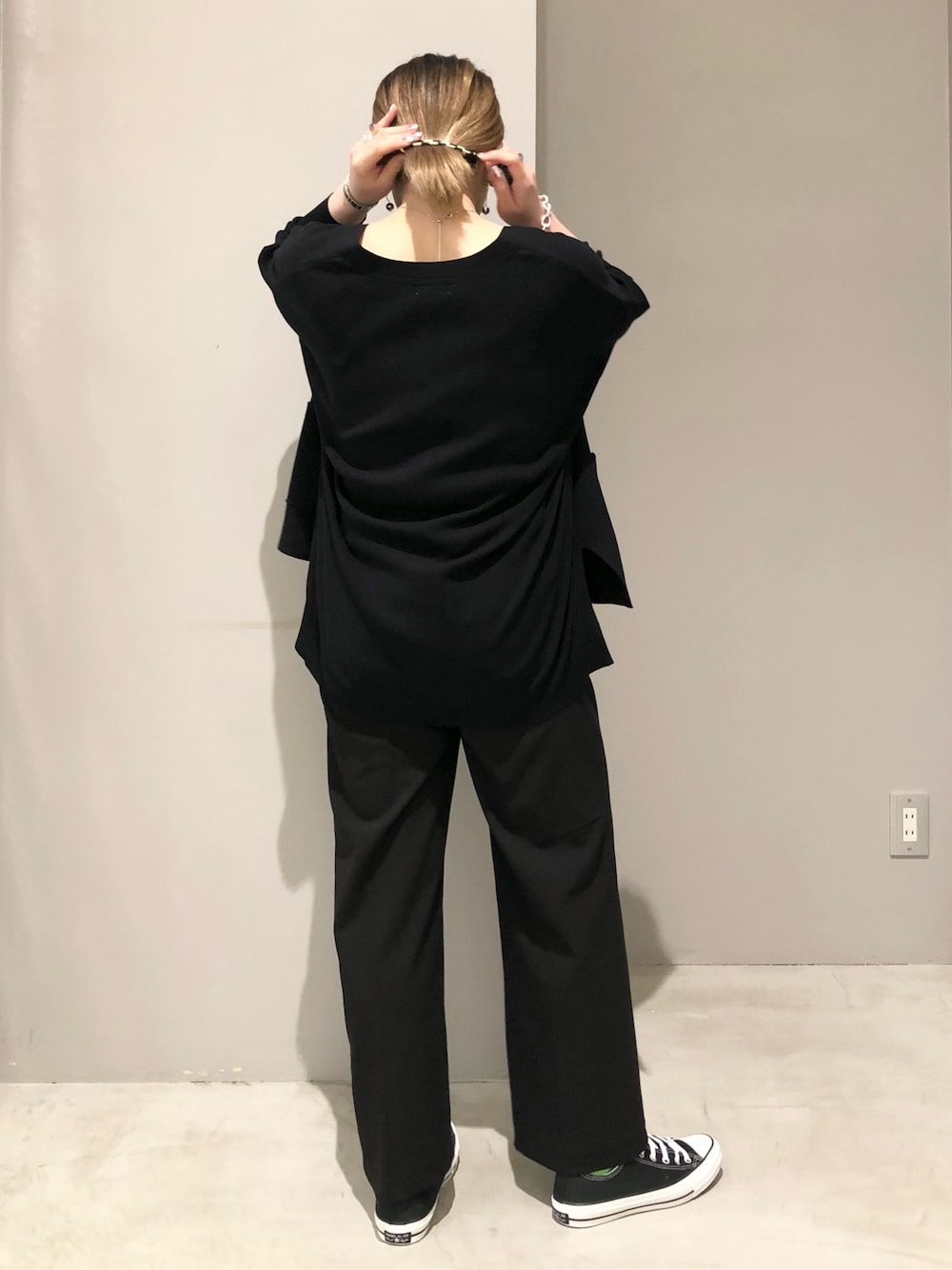 ブラック系のスニーカー、ブラック系のタンクトップ、ブラック系のスラックスを着用したレディースの春コーディネートの4枚目の写真