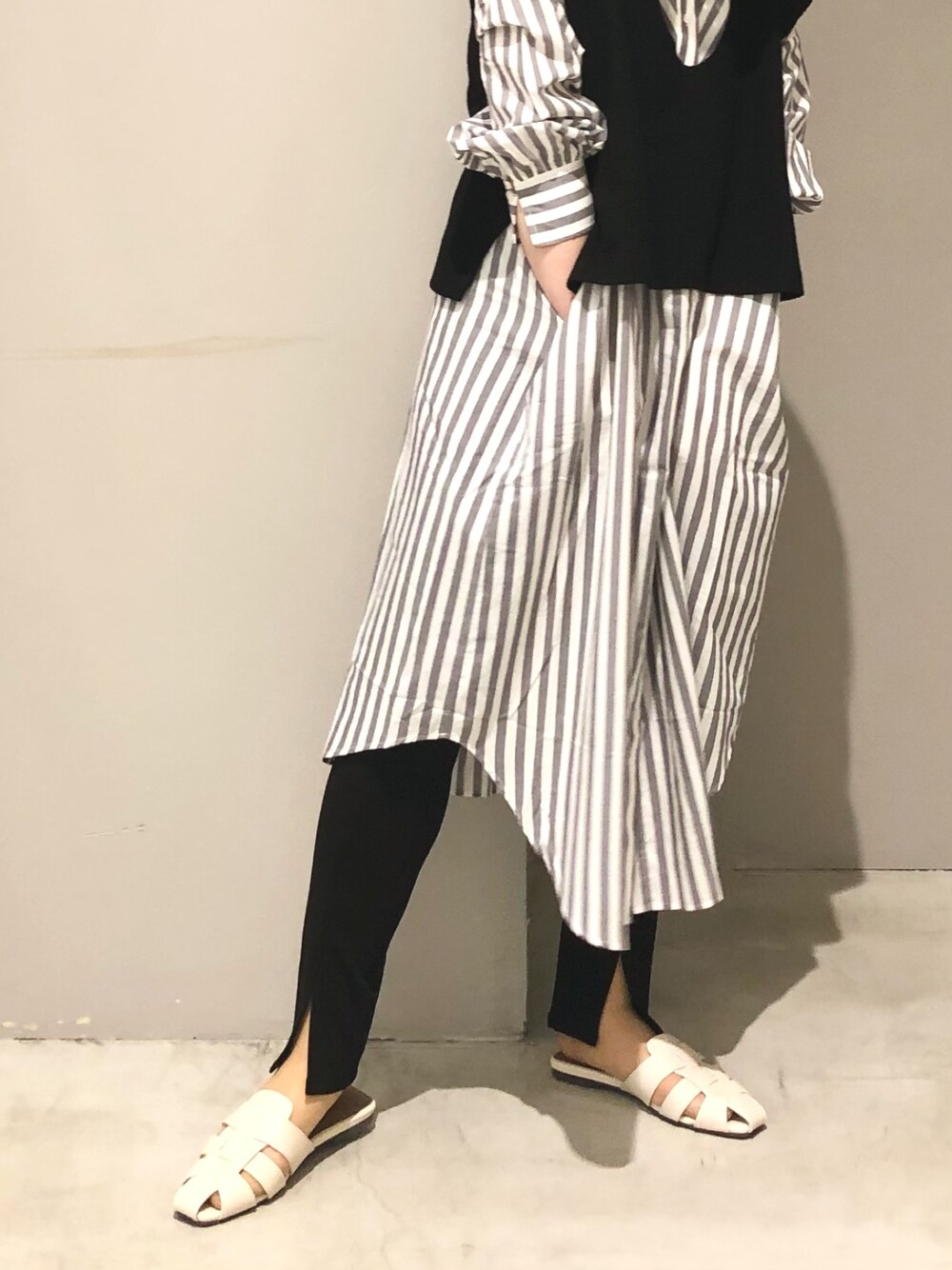 ブラック系のその他パンツ、ホワイト系のサンダル、ブラック系のベストを着用したレディースの春コーディネートの2枚目の写真