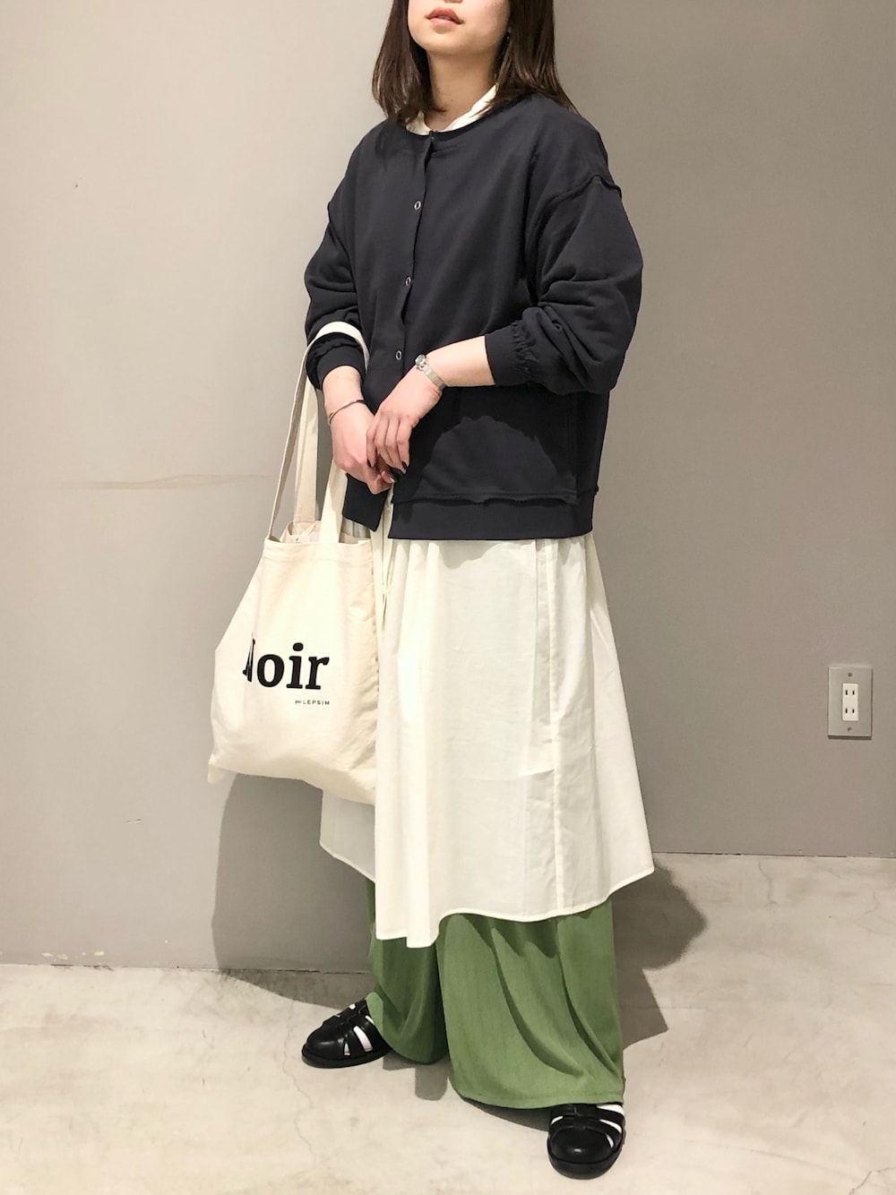 グレー系のカーディガン/ボレロ、ホワイト系のワンピース、グリーン系のその他パンツを着用したレディースの春コーディネートの2枚目の写真