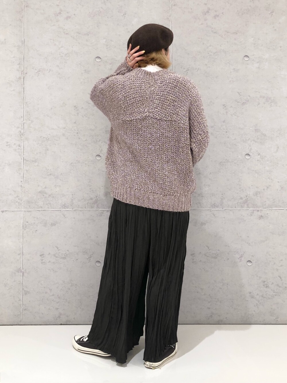 パープル系のニット/セーター、グレー系のその他パンツ、グレー系のスニーカーを着用したレディースの冬コーディネートの5枚目の写真