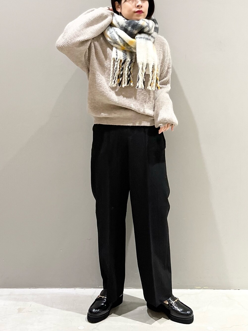 ブラウン系のニット/セーター、ブラック系のローファー、ブラック系のスラックスを着用したレディースの冬コーディネートの1枚目の写真