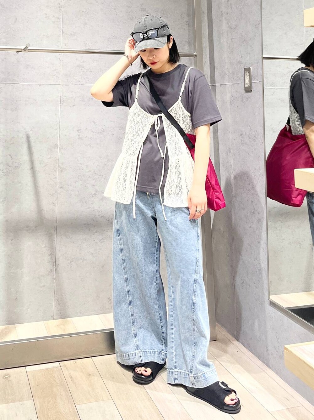 ブルー系のデニムパンツ、ブラック系のサンダル、ピンク系のショルダーバッグを着用したレディースの夏コーディネートの1枚目の写真