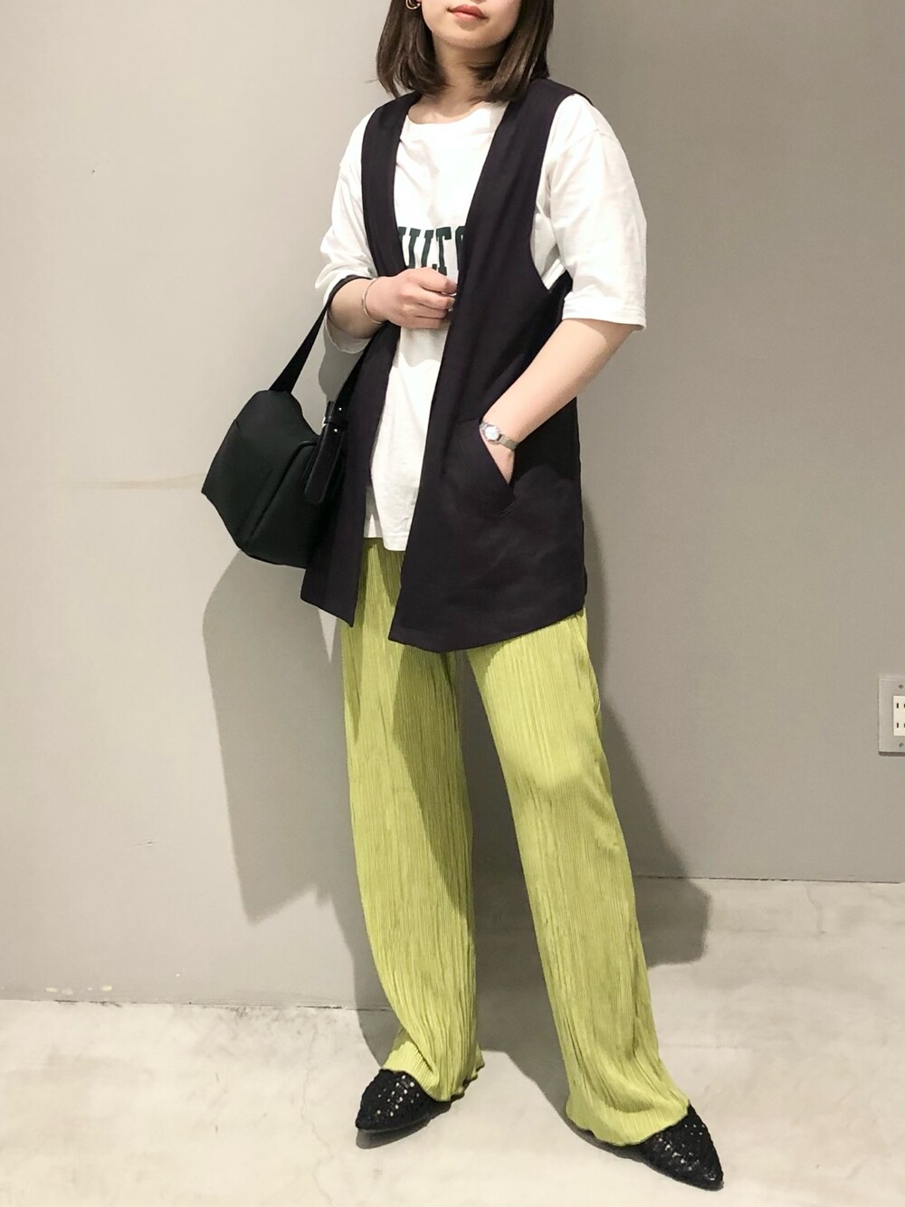 ホワイト系のTシャツ/カットソー、グレー系のベスト、グリーン系のその他パンツを着用したレディースの春コーディネートの2枚目の写真