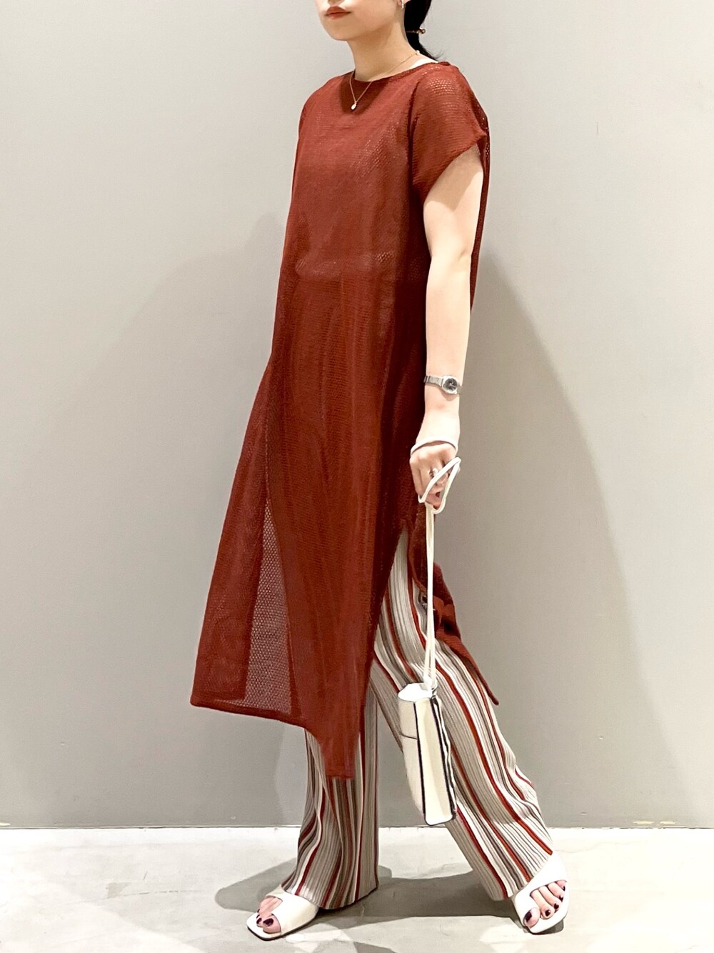 ブラウン系のワンピース、グレー系のパンツ、ホワイト系のサンダルを着用したレディースの秋コーディネートの3枚目の写真