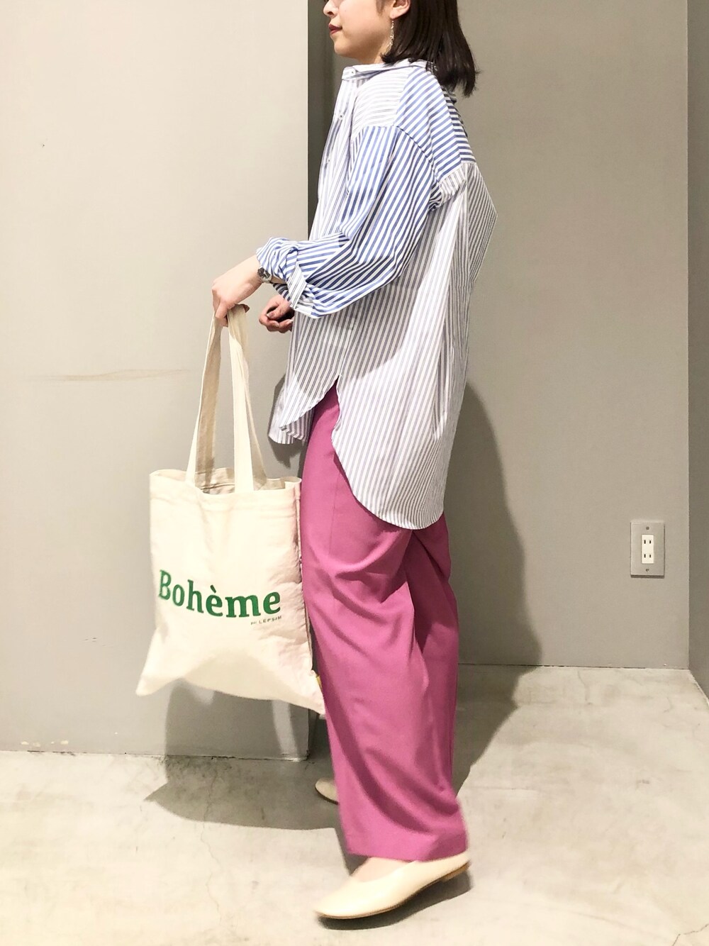 ピンク系のスラックス、ホワイト系のトートバッグ、ホワイト系のパンプスを着用したレディースの春コーディネートの2枚目の写真