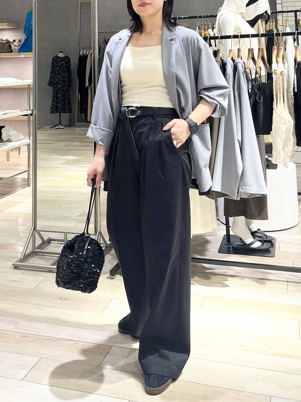 グレー系のチノパンツ、ブラック系のスニーカー、ホワイト系のキャミソールを着用したレディースの秋コーディネートの1枚目の写真