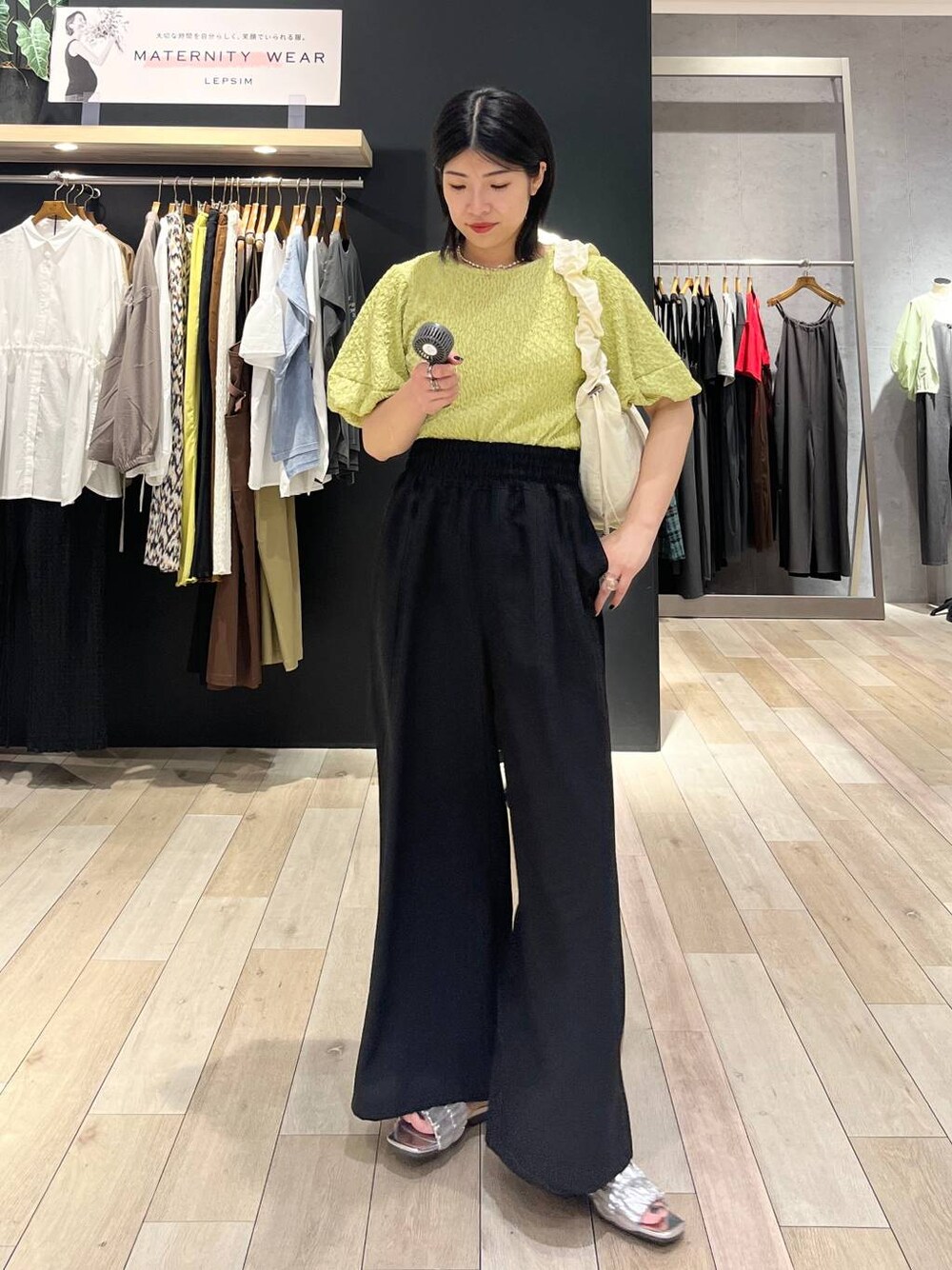 ブラック系のその他パンツ、グリーン系のTシャツ/カットソー、ホワイト系のショルダーバッグを着用したレディースの夏コーディネートの1枚目の写真