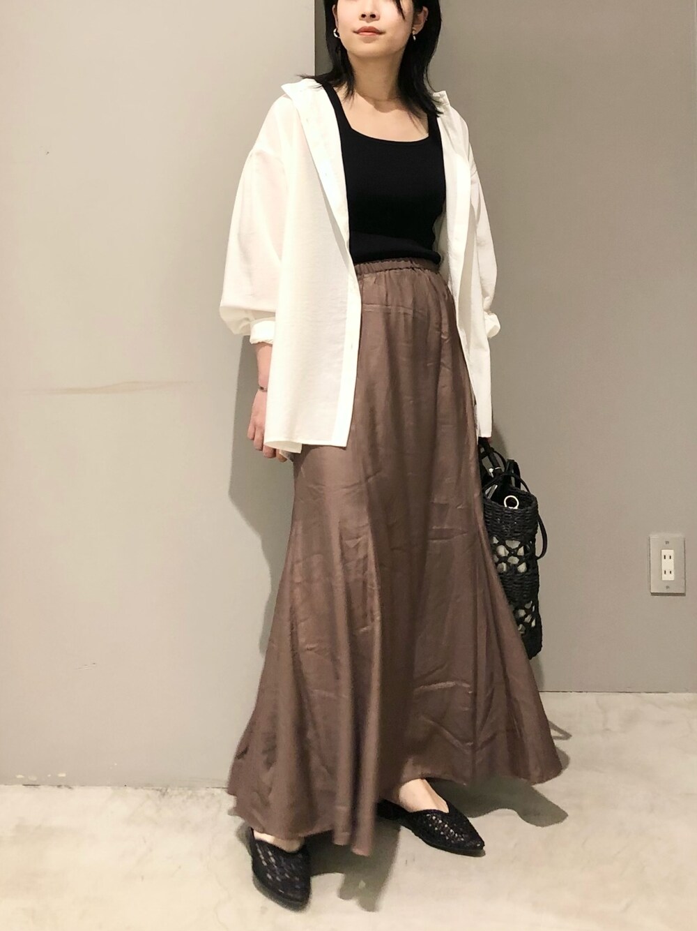 ホワイト系のシャツ/ブラウス、ブラック系のトートバッグ、ブラック系のサンダルを着用したレディースの夏コーディネートの2枚目の写真