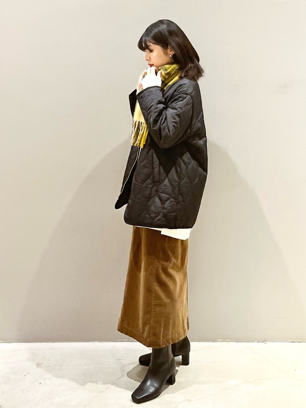 ブラウン系のスカート、ブラック系のブーツ、ブラック系のジャケット/アウターを着用したレディースの秋コーディネートの1枚目の写真