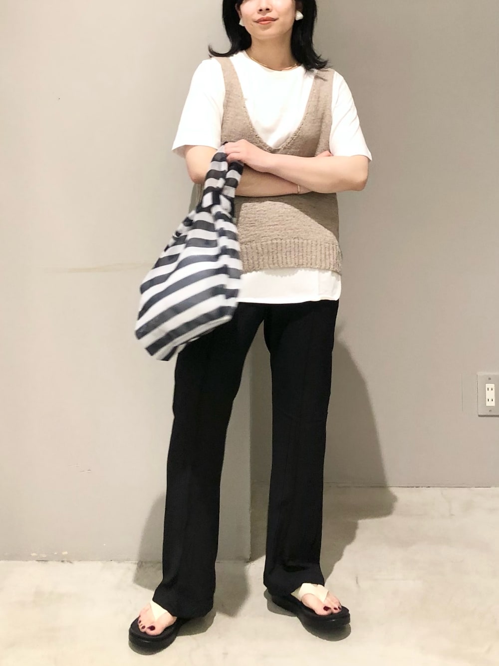 ブラック系のその他パンツ、ホワイト系のサンダル、ブルー系のトートバッグを着用したレディースの夏コーディネートの1枚目の写真