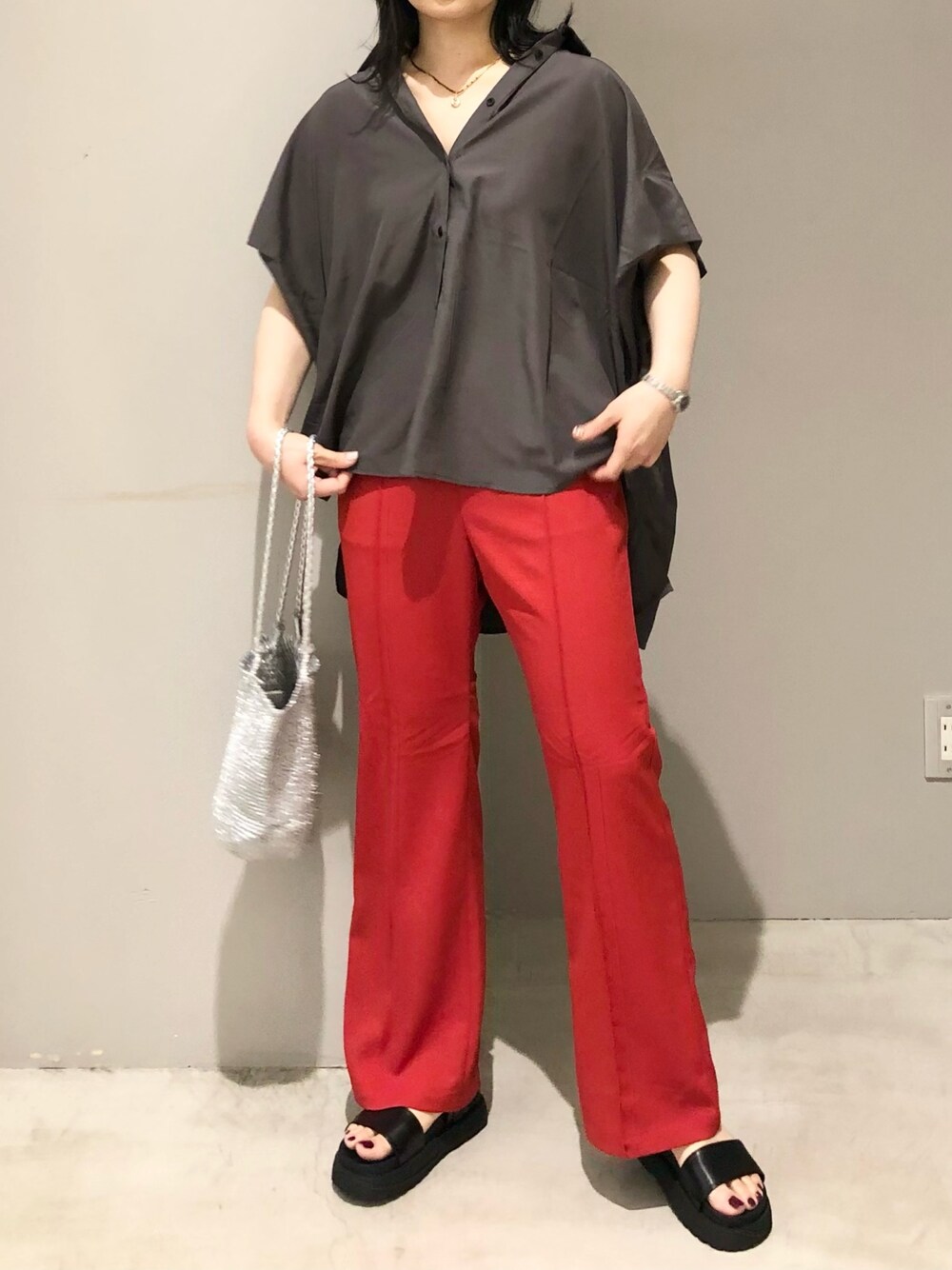 シルバー系のショルダーバッグ、レッド系のその他パンツ、ブラック系のサンダルを着用したレディースの夏コーディネートの3枚目の写真