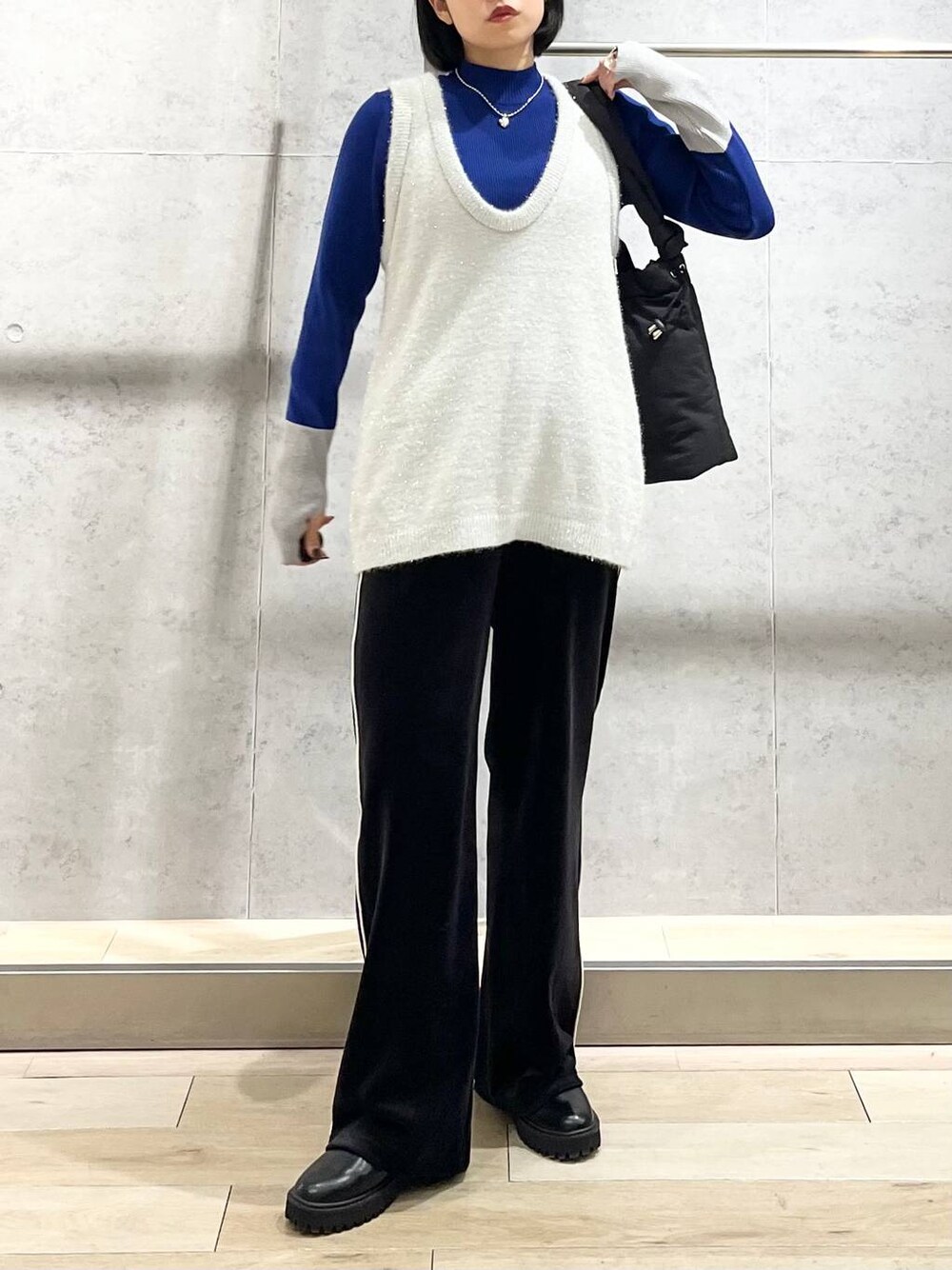 ブラック系のブーツ、ブルー系のニット/セーター、ブラック系のその他パンツを着用したレディースの冬コーディネートの1枚目の写真