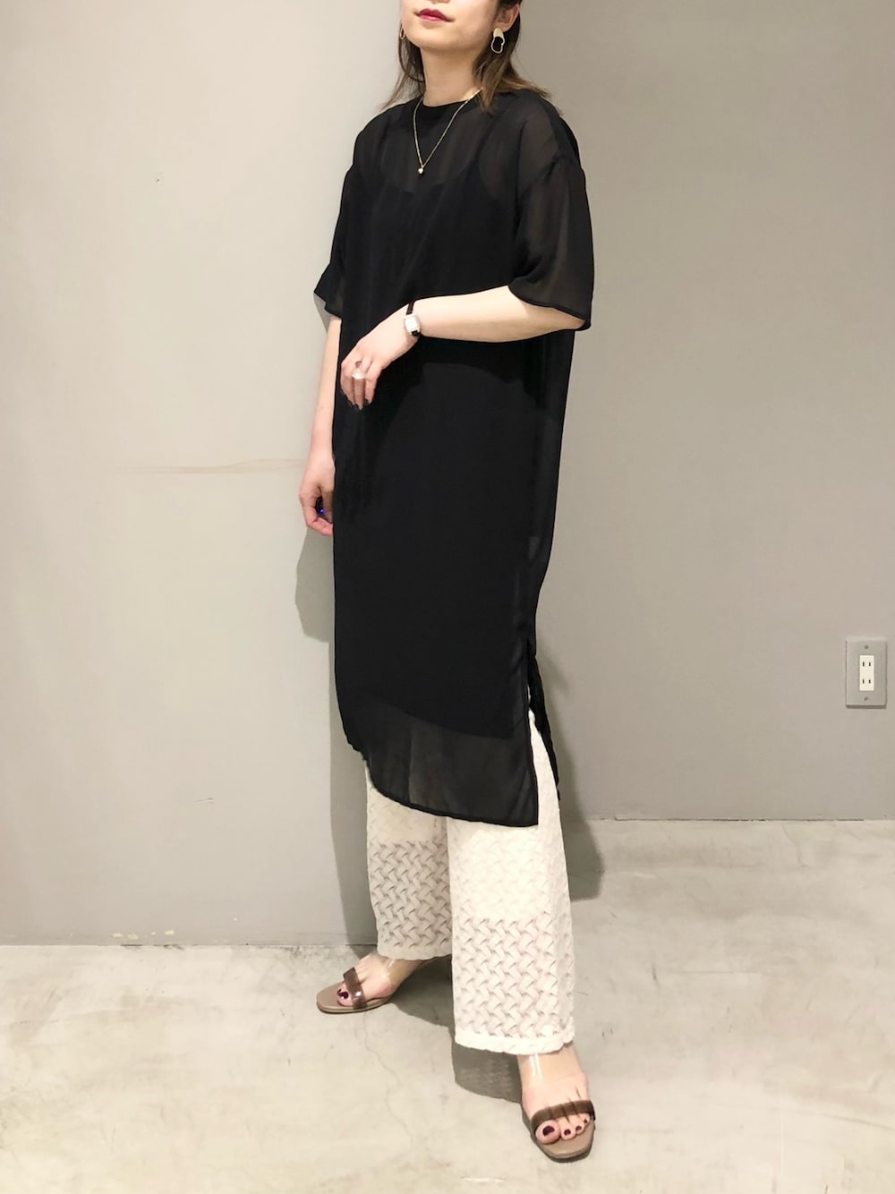 ブラック系のワンピース、ホワイト系のその他パンツ、ベージュ系のサンダルを着用したレディースの夏コーディネートの3枚目の写真