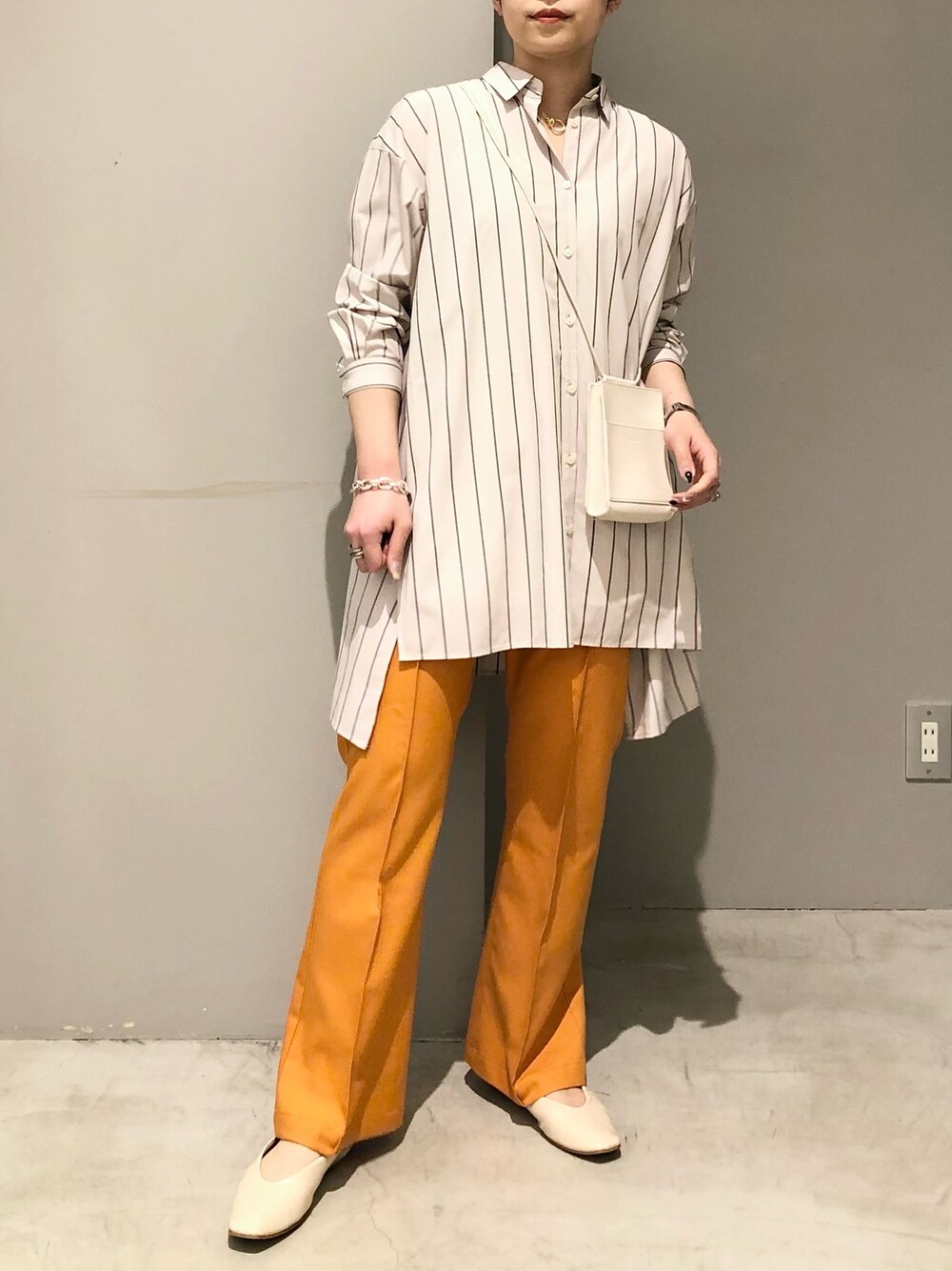 ベージュ系のシャツ/ブラウス、オレンジ系のその他パンツ、ホワイト系のパンプスを着用したレディースの春コーディネートの2枚目の写真