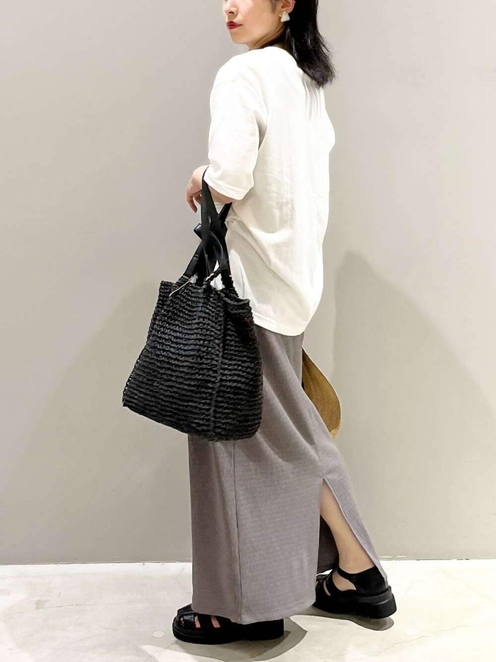 ブラウン系のスカート、ブラック系のサンダル、ホワイト系のTシャツ/カットソーを着用したレディースの夏コーディネートの2枚目の写真