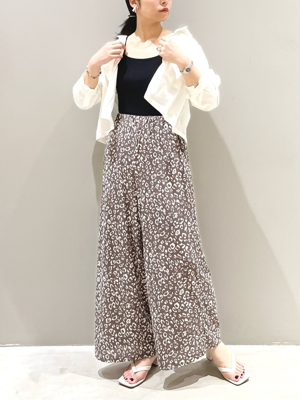 ホワイト系のサンダル、ホワイト系のシャツ/ブラウス、ブラック系のタンクトップを着用したレディースの夏コーディネートの2枚目の写真