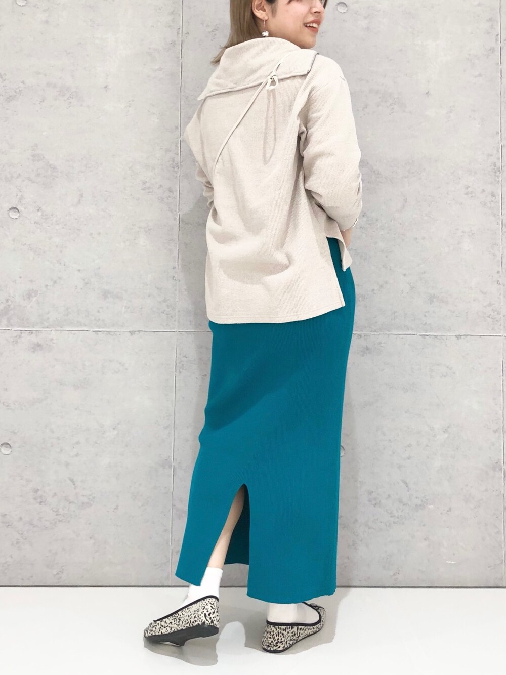 グリーン系のスカート、その他のバレエシューズ、ホワイト系のショルダーバッグを着用したレディースの冬コーディネートの3枚目の写真