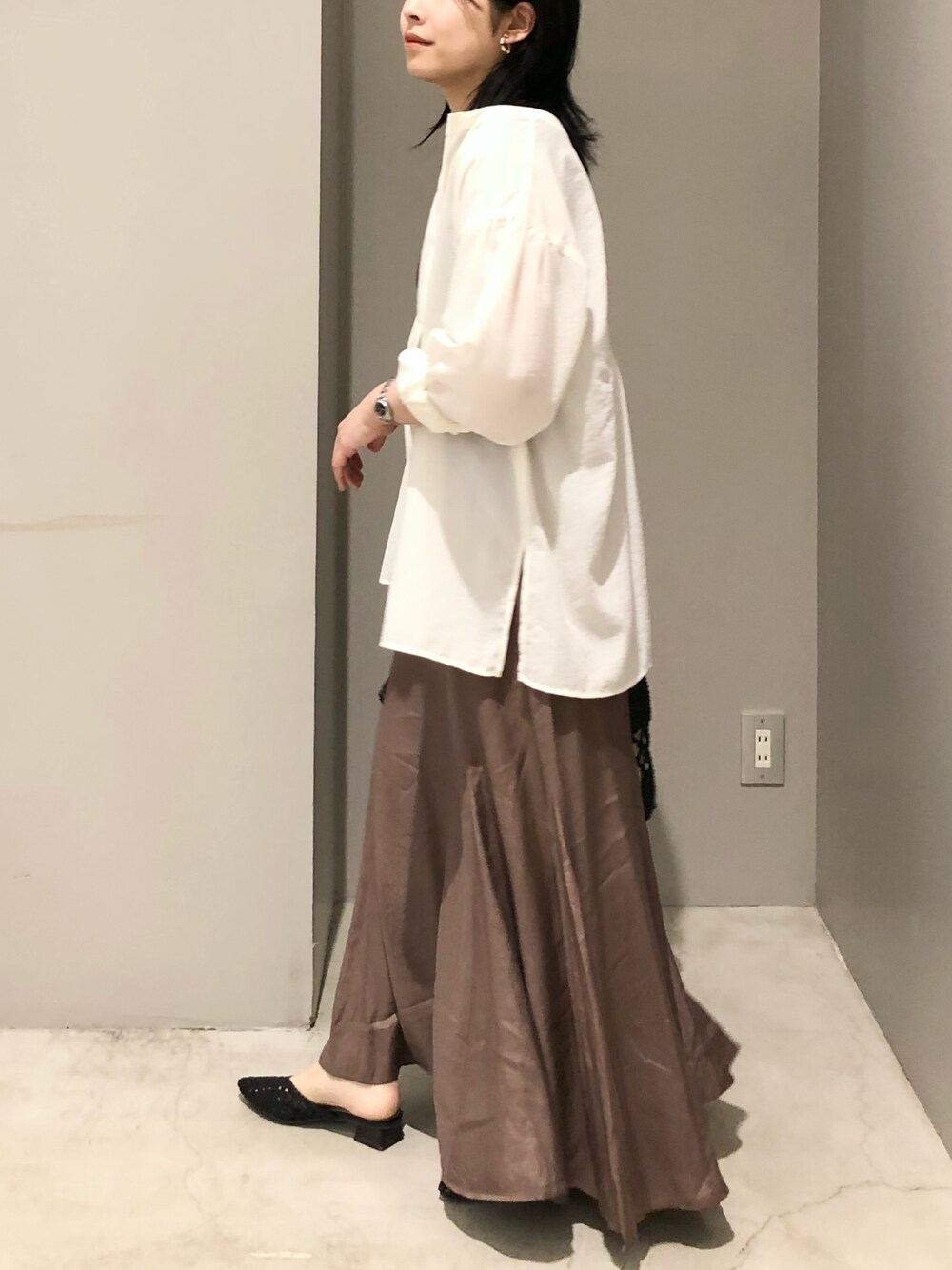 ホワイト系のシャツ/ブラウス、ブラック系のトートバッグ、ブラック系のサンダルを着用したレディースの夏コーディネートの3枚目の写真