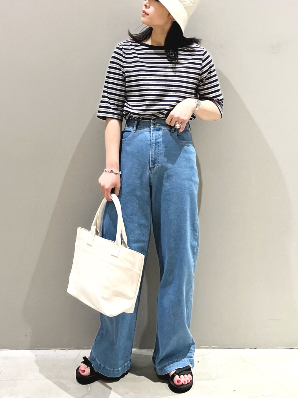 ブルー系のTシャツ/カットソー、ブルー系のデニムパンツ、ホワイト系のトートバッグを着用したレディースの夏コーディネートの1枚目の写真