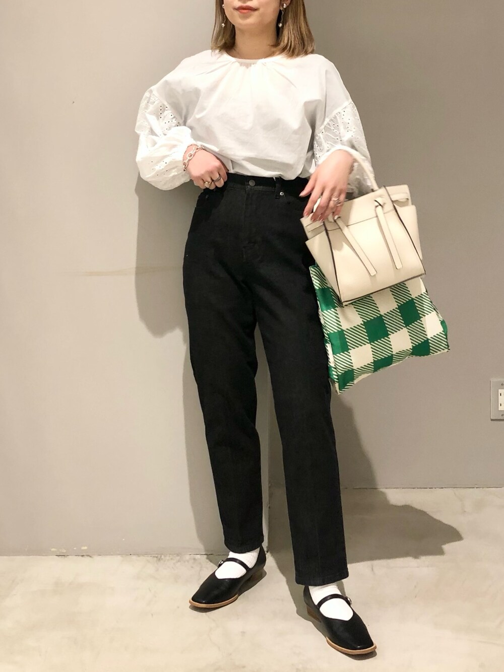 ホワイト系のショルダーバッグ、グリーン系のショルダーバッグ、ブラック系のパンプスを着用したレディースの春コーディネートの2枚目の写真