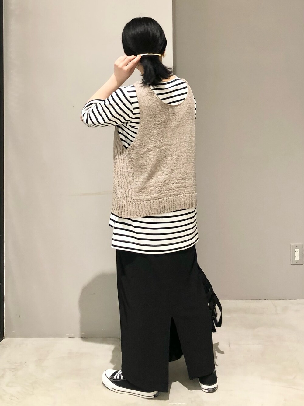 ブラック系のスニーカー、ブラック系のスカート、ブラック系のバックパック/リュックを着用したレディースの夏コーディネートの3枚目の写真