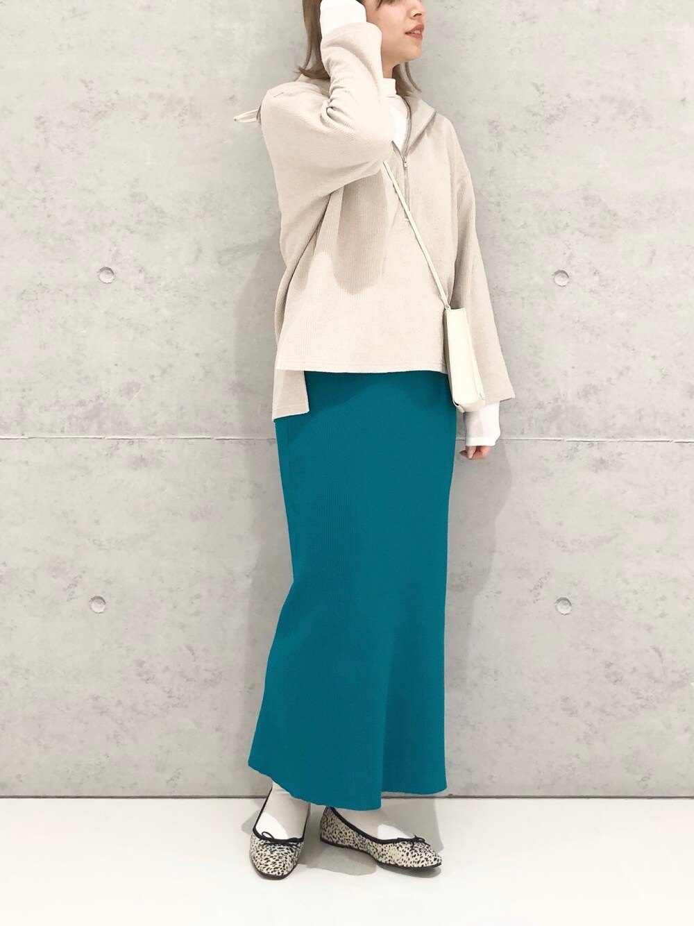 グリーン系のスカート、その他のバレエシューズ、ホワイト系のショルダーバッグを着用したレディースの冬コーディネートの2枚目の写真