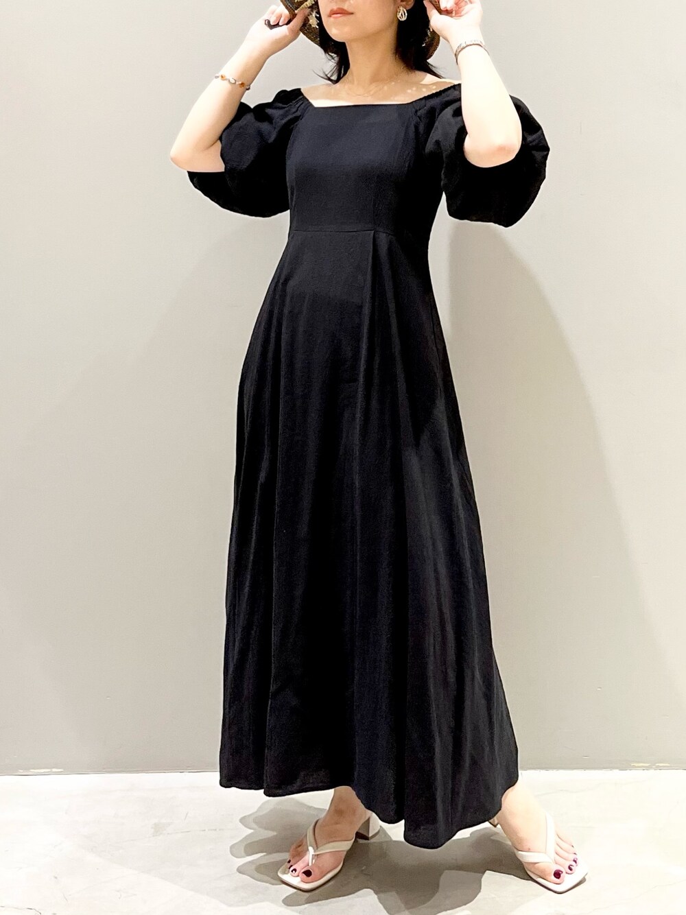 ホワイト系のサンダル、ブラック系のワンピース、その他のハットを着用したレディースの夏コーディネートの3枚目の写真