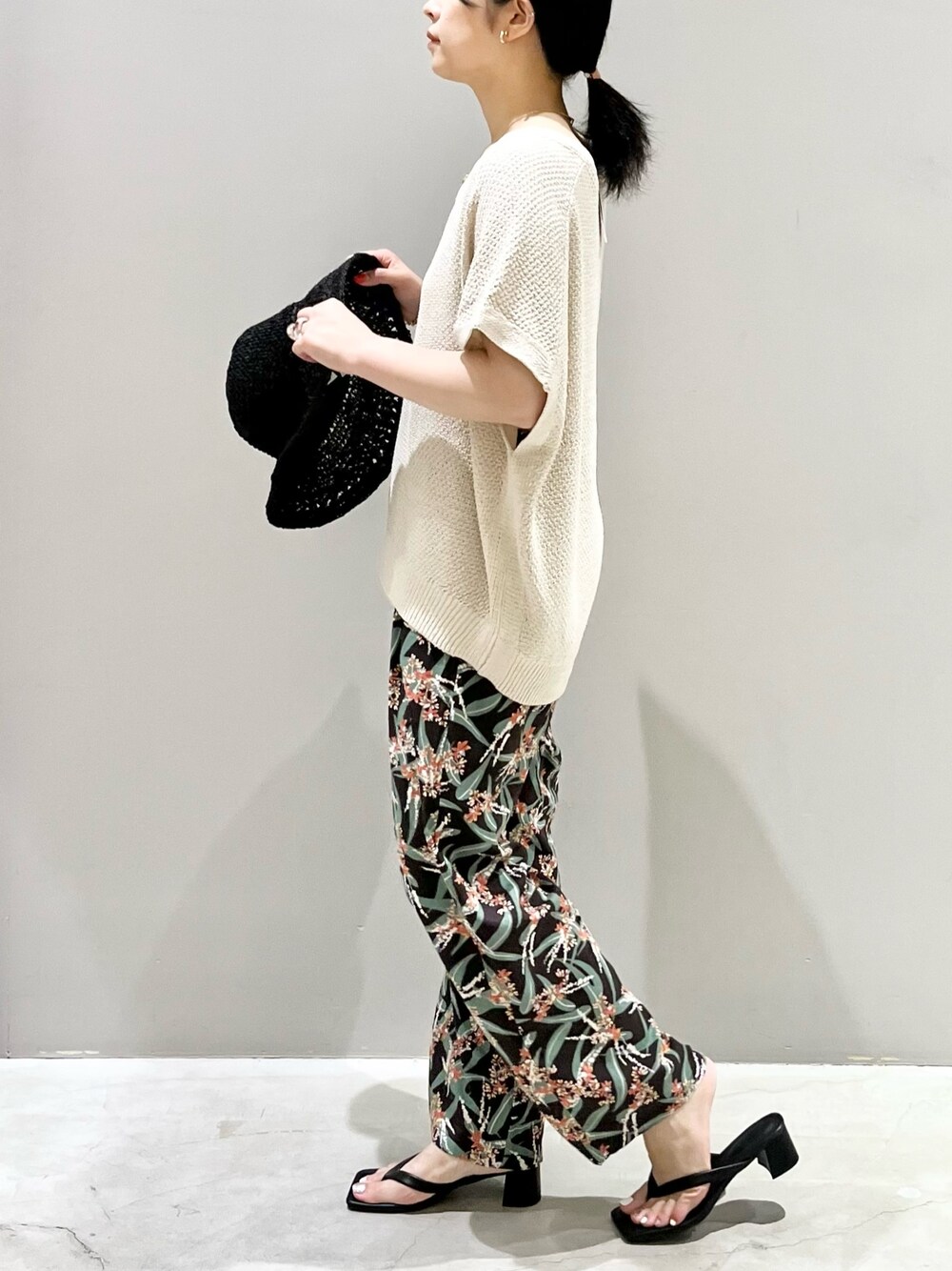 ホワイト系のニット/セーター、ブラック系のその他パンツ、ブラック系のサンダルを着用したレディースの夏コーディネートの2枚目の写真