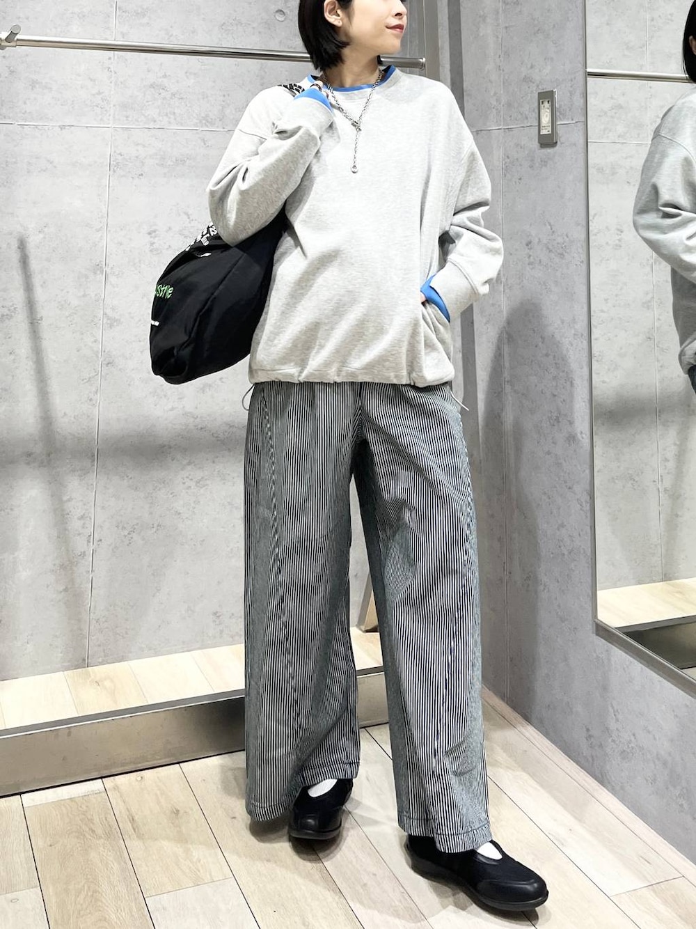 ブラック系のパンプス、ブラック系のトートバッグ、グレー系のTシャツ/カットソーを着用したレディースの冬コーディネートの1枚目の写真