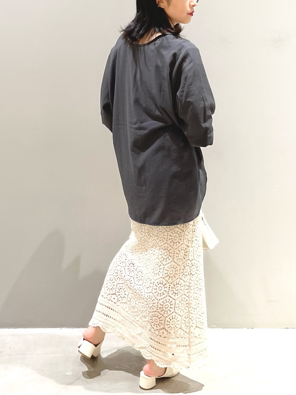 ホワイト系のスカート、ホワイト系のサンダル、ホワイト系のショルダーバッグを着用したレディースの夏コーディネートの3枚目の写真