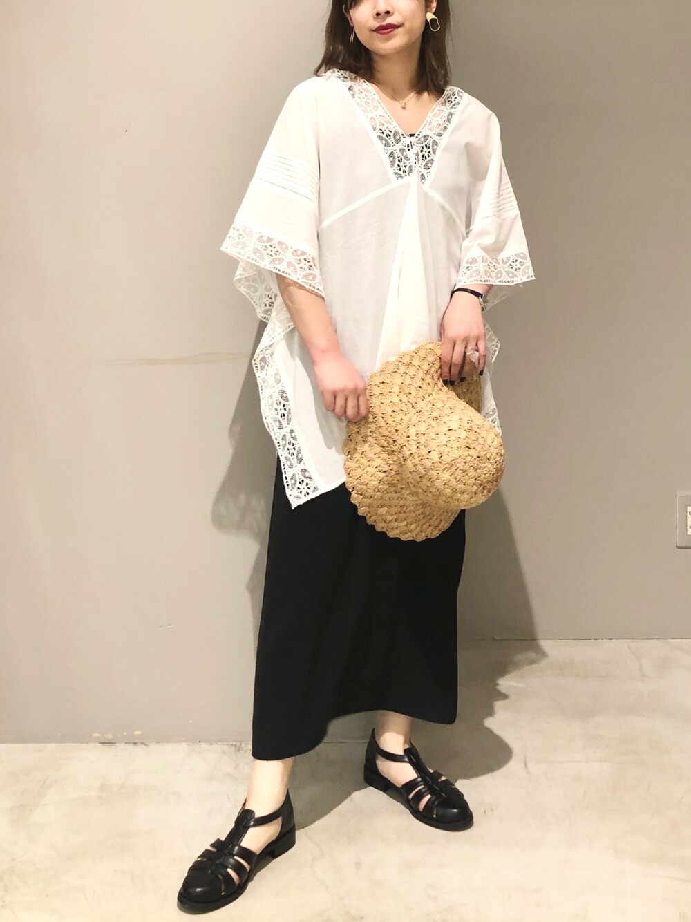 ホワイト系のシャツ/ブラウス、ブラック系のスカート、ブラック系のサンダルを着用したレディースの夏コーディネートの2枚目の写真