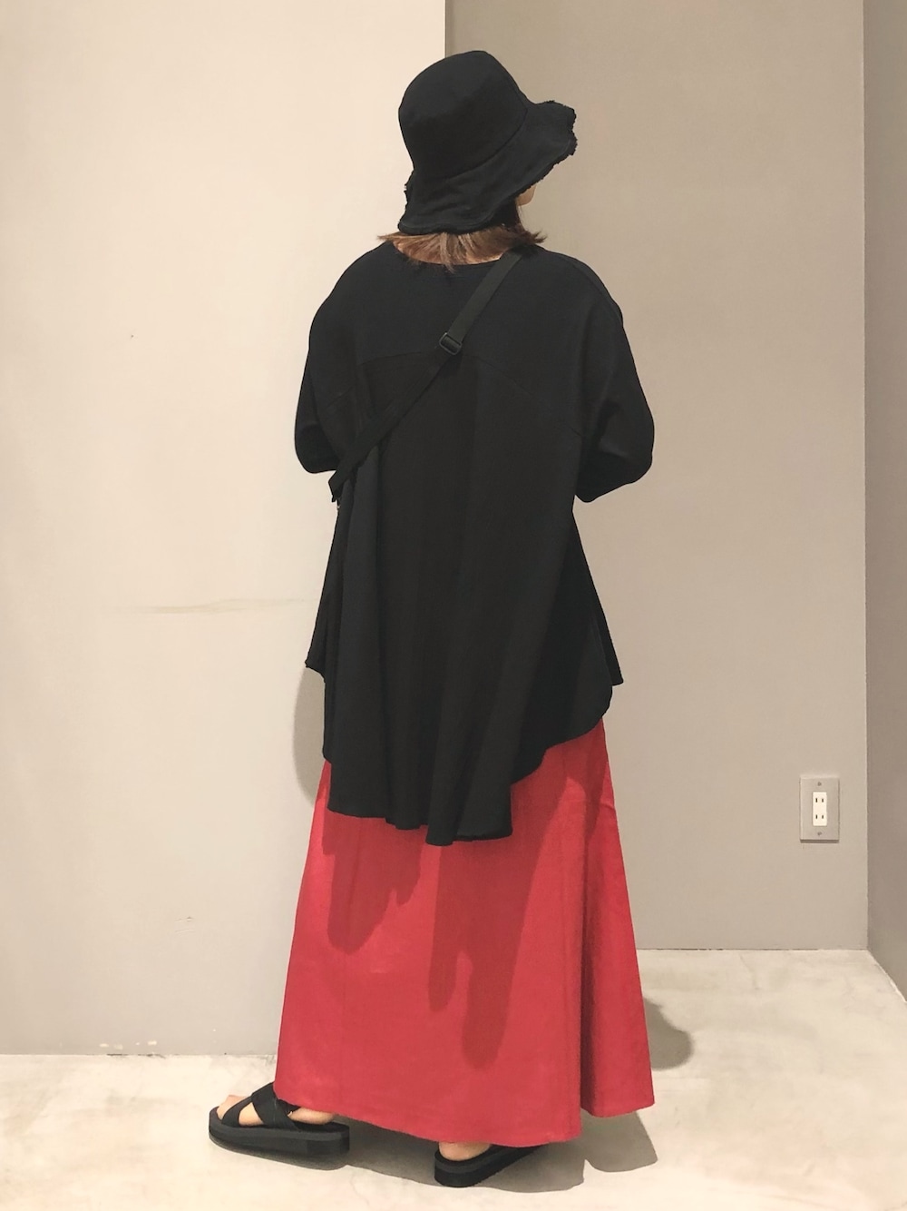 レッド系のスカート、ブラック系のサンダル、その他のショルダーバッグを着用したレディースの春コーディネートの3枚目の写真