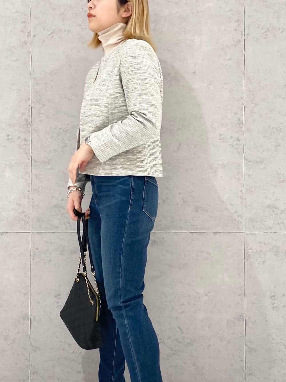 ブラック系のジャケット/アウター、ブルー系のデニムパンツ、ブラック系のショルダーバッグを着用したレディースの冬コーディネートの3枚目の写真