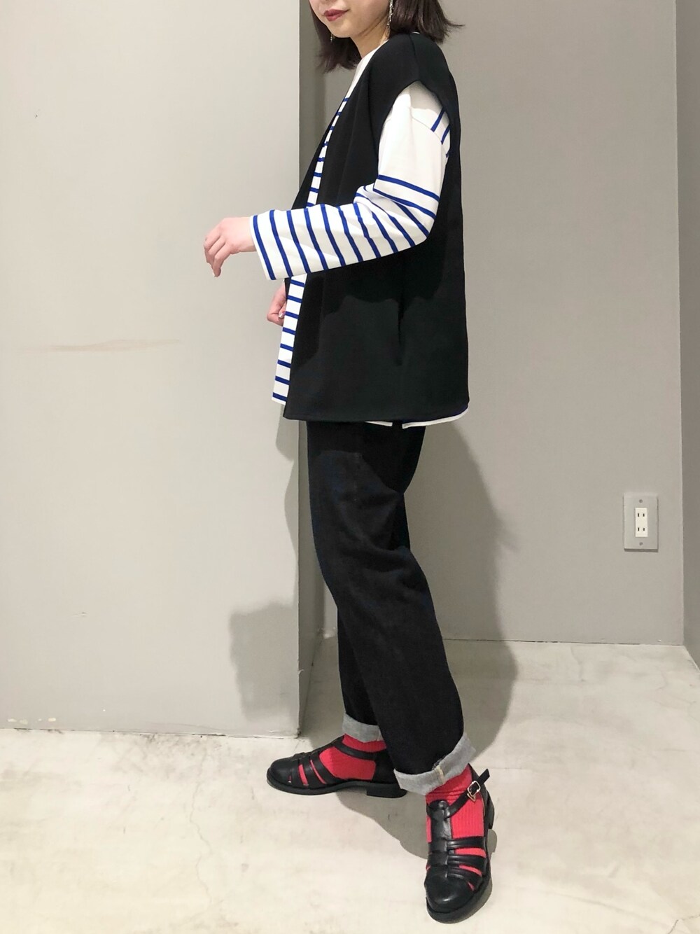 ブラック系のその他アウター、ブルー系のTシャツ/カットソー、ブルー系のデニムパンツを着用したレディースの春コーディネートの2枚目の写真