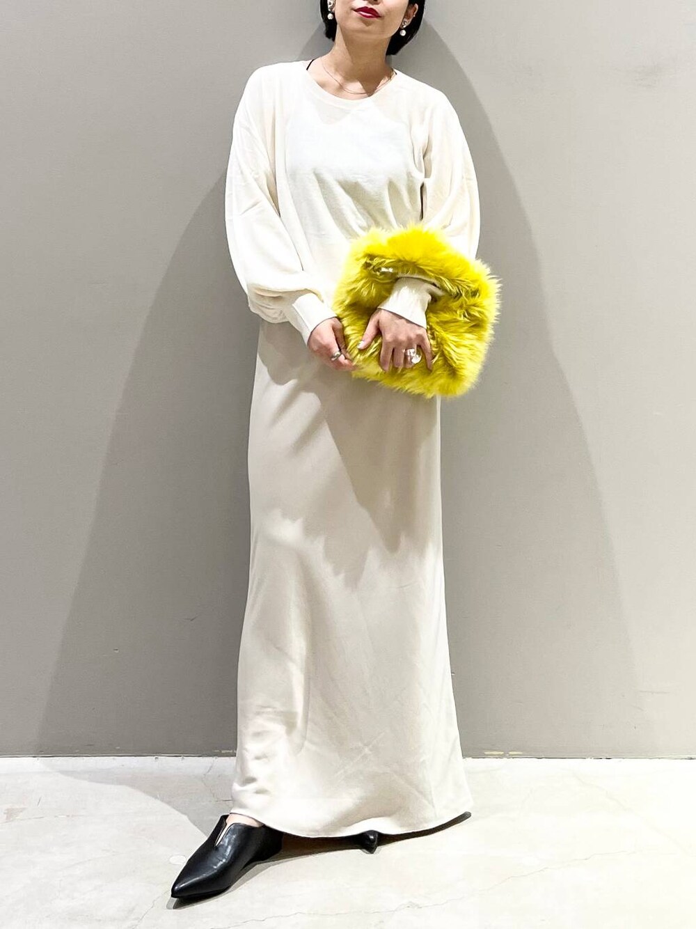 ブラック系のキャミソール、ホワイト系のニット/セーター、イエロー系のハンドバッグを着用したレディースの秋コーディネートの1枚目の写真