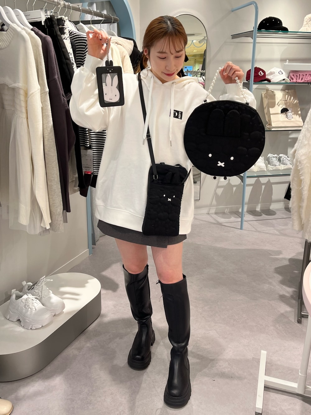 ホワイト系のパーカー、ブラック系のショルダーバッグ、ブラック系のハンドバッグを着用したレディースの冬コーディネートの1枚目の写真