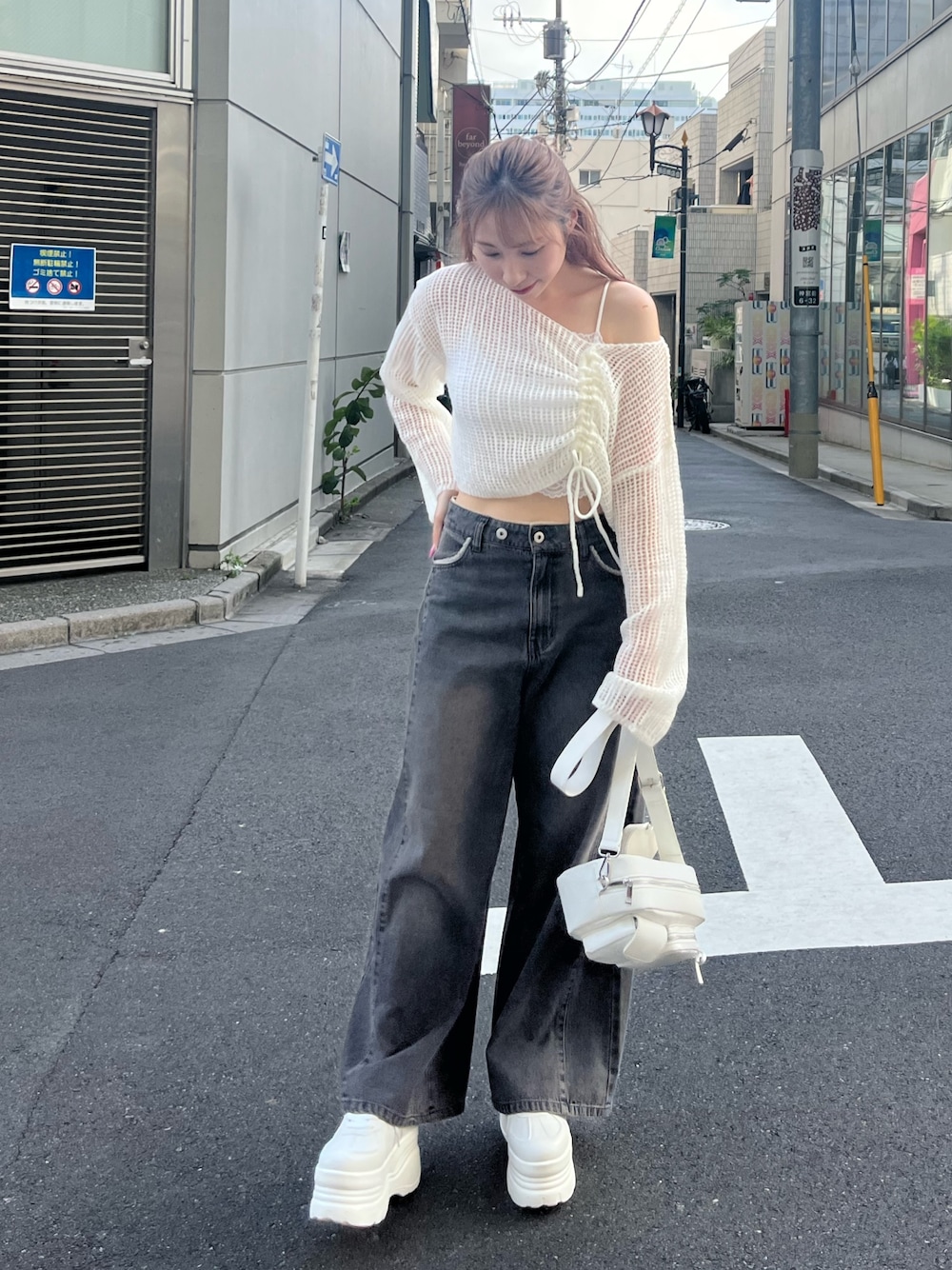 ホワイト系のニット/セーター、ブラック系のデニムパンツ、ホワイト系のスニーカーを着用したレディースの秋コーディネートの1枚目の写真