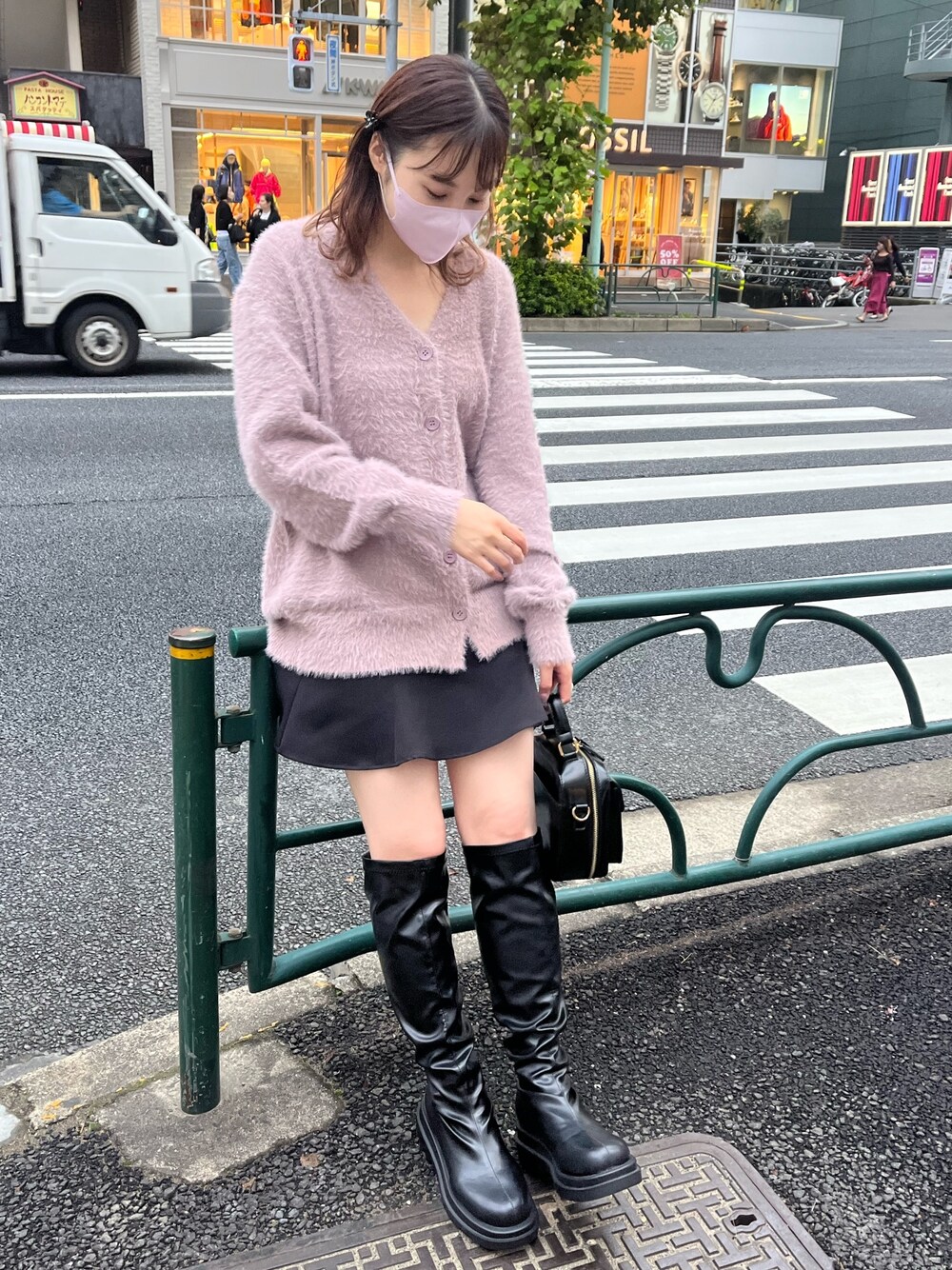 パープル系のカーディガン/ボレロ、ブラック系のスカート、ブラック系のブーツを着用したレディースの秋コーディネートの1枚目の写真