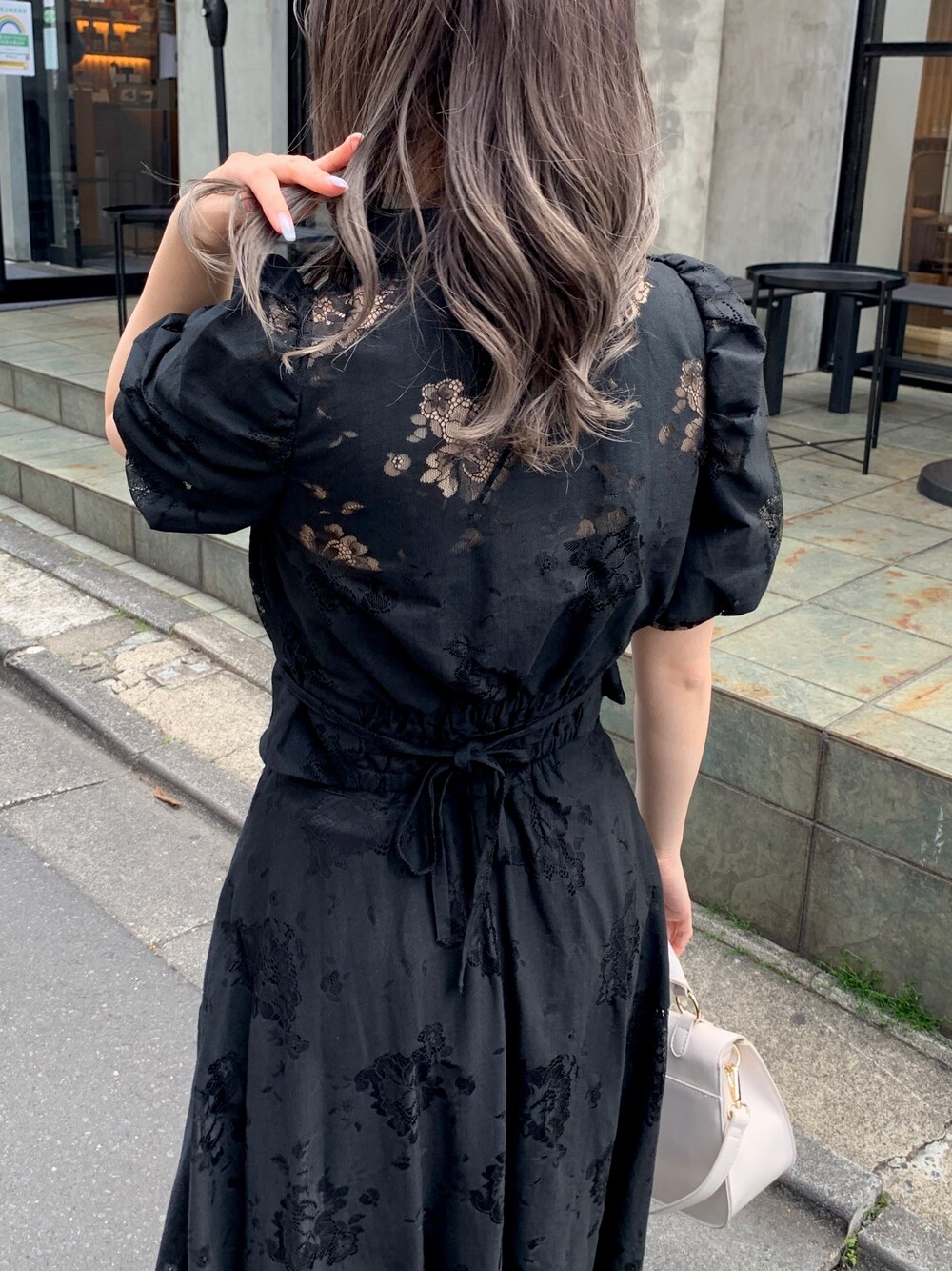 ブラック系のシャツ/ブラウス、ブラック系のスカート、ゴールド系のサンダルを着用したレディースの春コーディネートの3枚目の写真