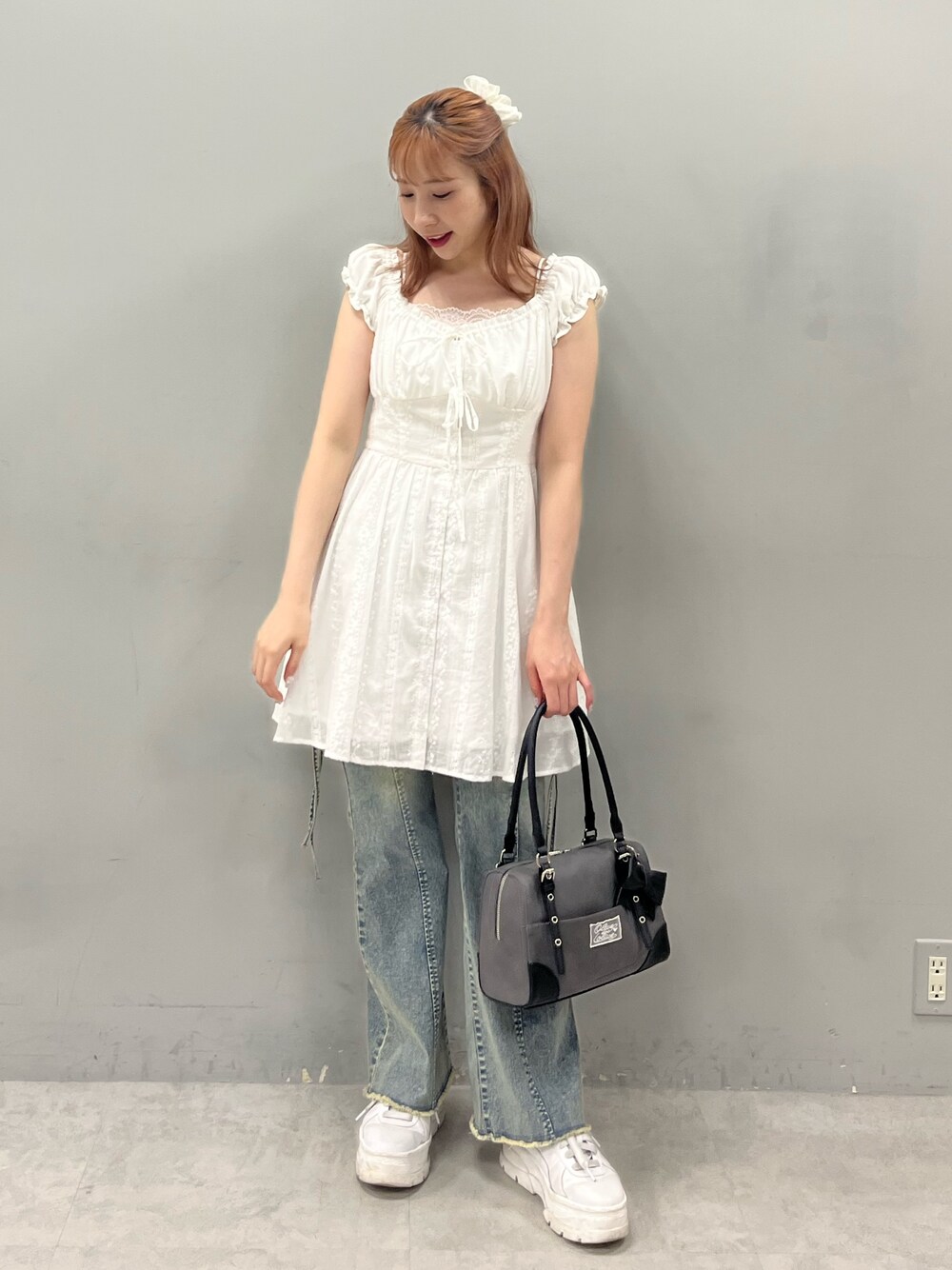 ホワイト系のワンピース、ブルー系のデニムパンツ、ブラック系のショルダーバッグを着用したレディースの夏コーディネートの1枚目の写真