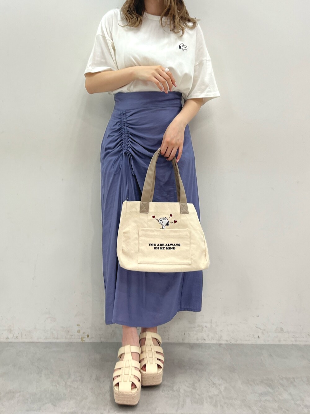 ホワイト系のTシャツ/カットソー、ブルー系のスカート、ホワイト系のバッグを着用したレディースの春コーディネートの1枚目の写真