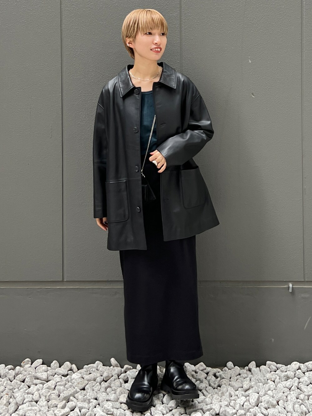 ブラック系のライダースジャケット、グリーン系のTシャツ/カットソー、ブラック系のブーツを着用したレディースの秋コーディネートの1枚目の写真