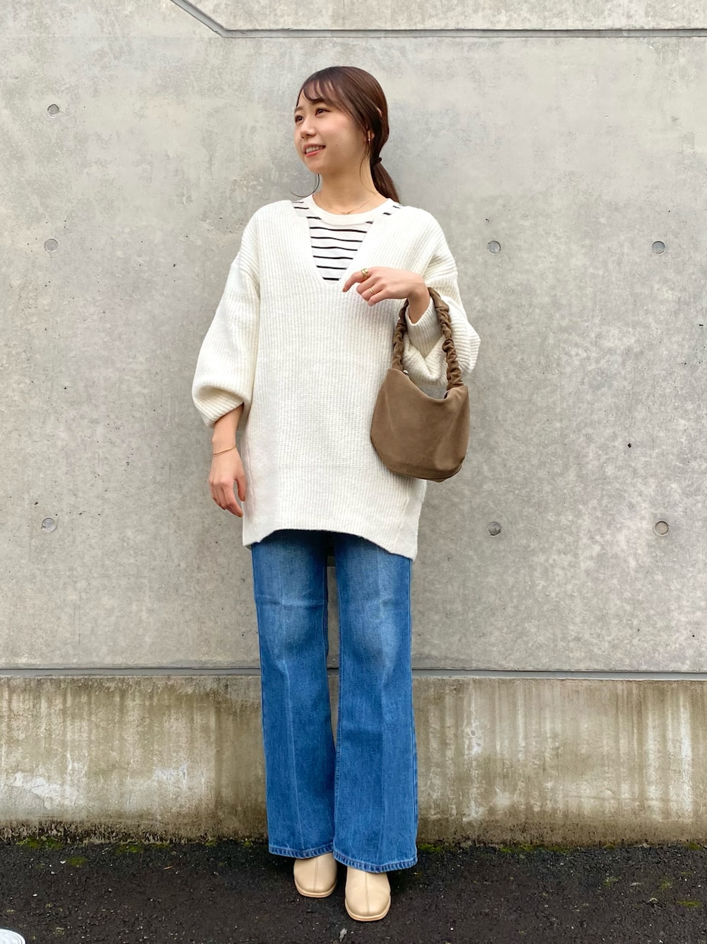 ホワイト系のニット/セーター、ブルー系のデニムパンツ、ベージュ系のブーツを着用したレディースの冬コーディネートの1枚目の写真