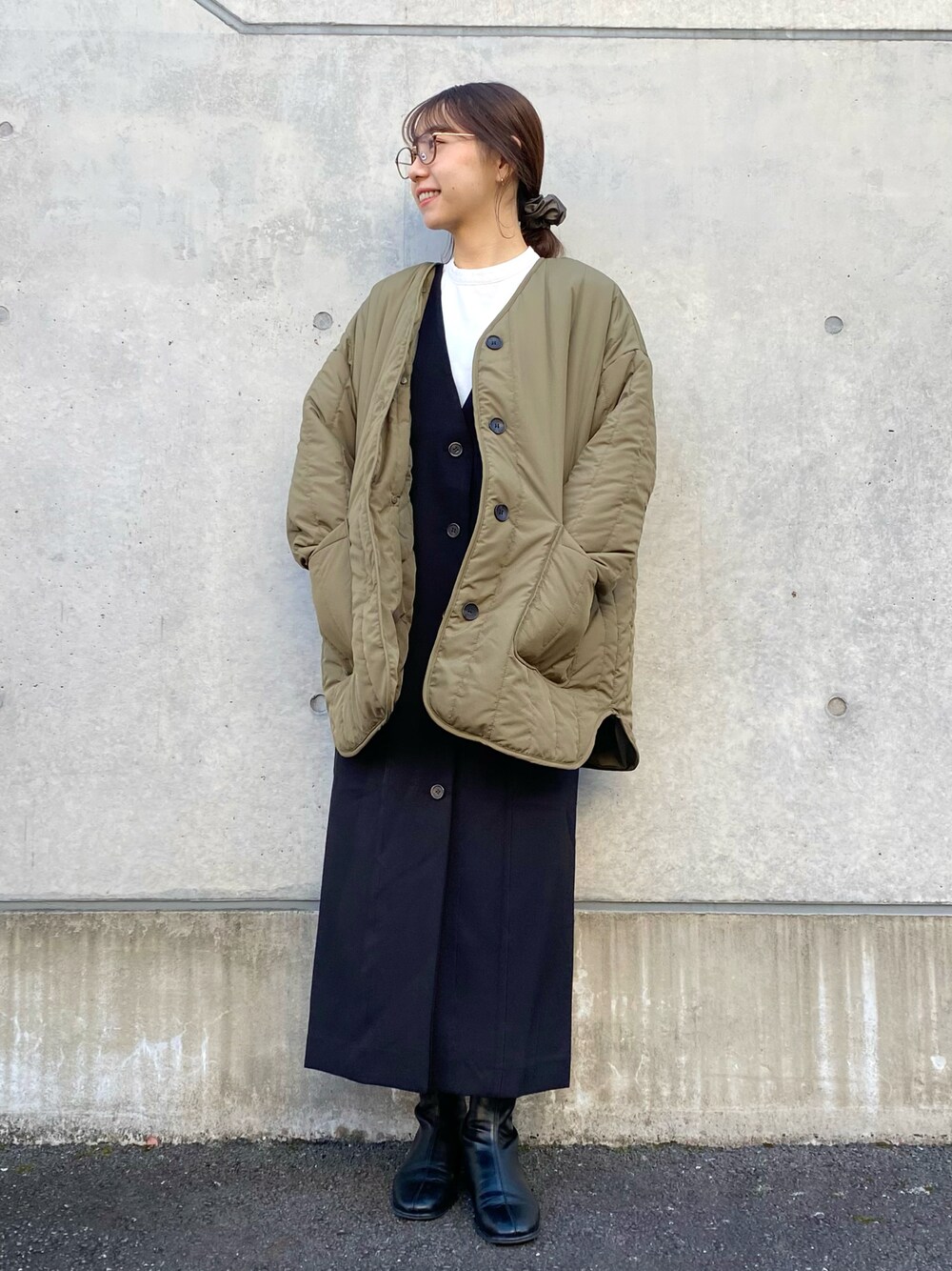 グリーン系のその他アウター、ブラック系のジャンパースカート、ホワイト系のTシャツ/カットソーを着用したレディースの冬コーディネートの1枚目の写真