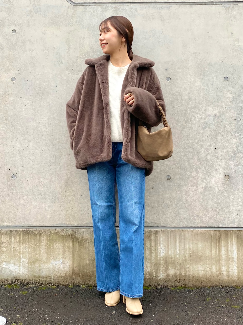 ホワイト系のニット/セーター、ブルー系のデニムパンツ、ベージュ系のブーツを着用したレディースの冬コーディネートの1枚目の写真