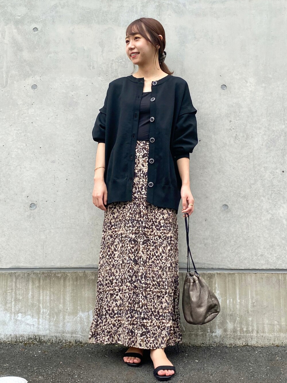 ブラック系のカーディガン/ボレロ、ベージュ系のスカート、ブラック系のキャミソールを着用したレディースの秋コーディネートの1枚目の写真