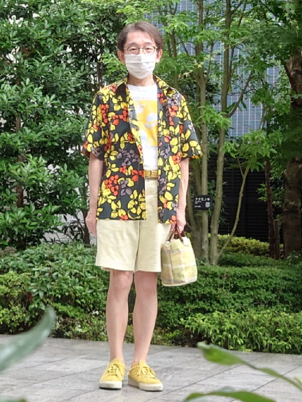 イエロー系のスニーカー、グリーン系のトートバッグ、ホワイト系のTシャツ/カットソーを着用したメンズの夏コーディネートの1枚目の写真