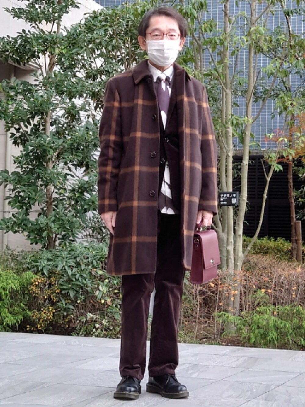 ブラウン系のその他パンツ、ブラック系のドレスシューズ、レッド系のショルダーバッグを着用したメンズの冬コーディネートの1枚目の写真