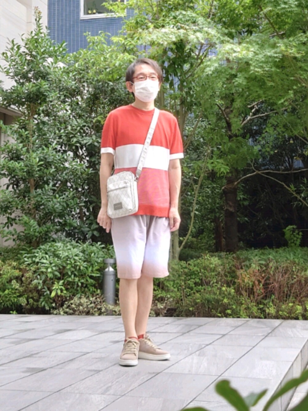 ベージュ系のスニーカー、レッド系のニット/セーター、ホワイト系のバッグを着用したメンズの夏コーディネートの1枚目の写真